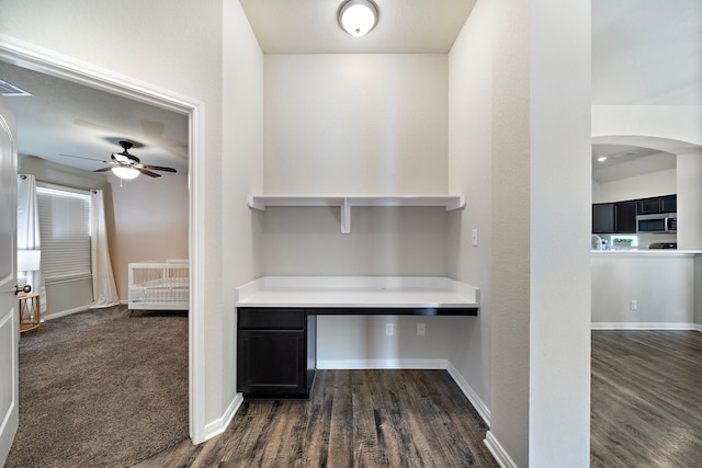 1074 Pleasant Bnd, Conroe, TX 77301 - unfurnished office with a ceiling fan, dark wood-style floors, arched walkways, and built in study area