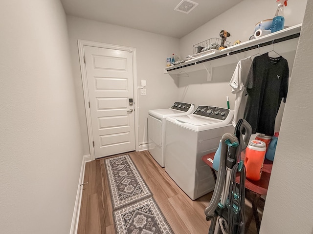 laundry room featuring washer and dryer, laundry area, visible vents, and light wood-style floors