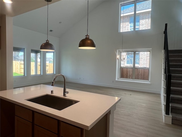 2223 Inglenook Grove Dr, Katy, TX 77493 - kitchen featuring high vaulted ceiling, light countertops, light wood finished floors, hanging light fixtures, and open floor plan