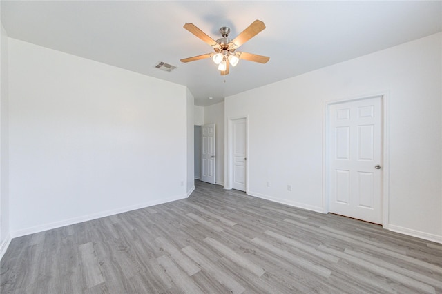 spare room featuring visible vents, light wood-style flooring, ceiling fan, and baseboards