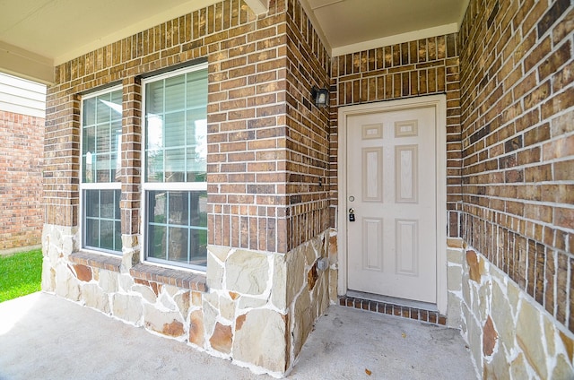 doorway to property with brick siding