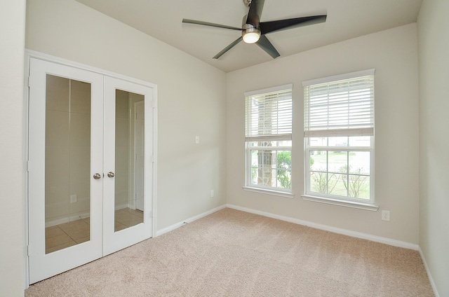 carpeted empty room with baseboards, ceiling fan, and french doors