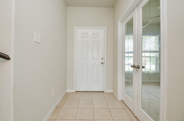 entryway featuring french doors, baseboards, and light tile patterned floors