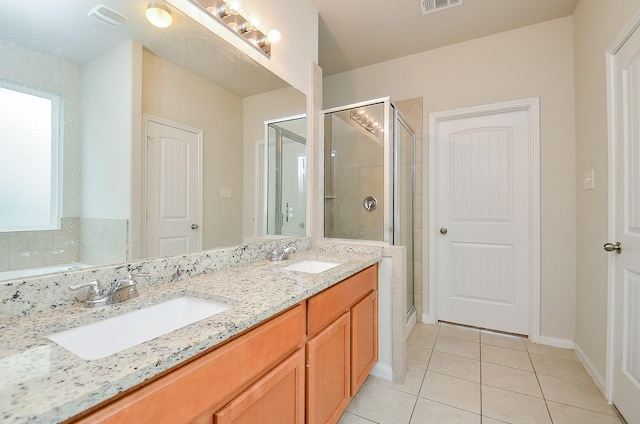 full bath with tile patterned floors, visible vents, a shower stall, and a sink