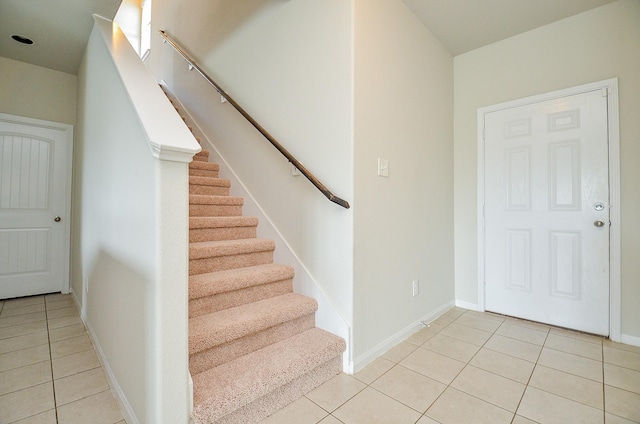 foyer featuring stairway, baseboards, and light tile patterned flooring