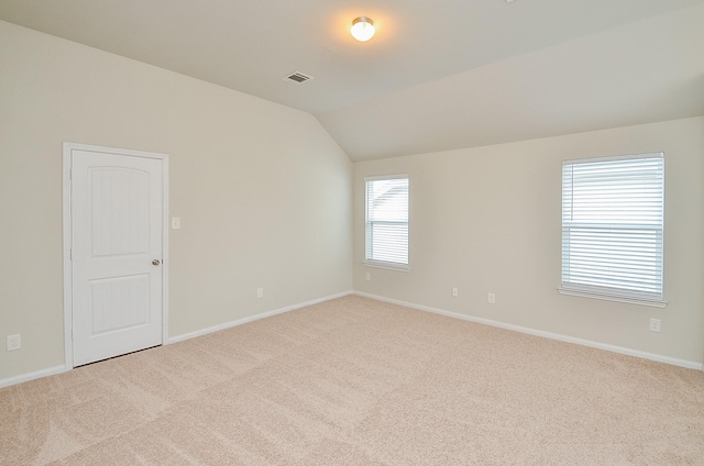 unfurnished room with visible vents, lofted ceiling, and carpet