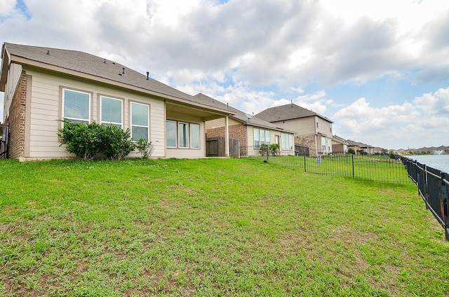 back of property with a fenced backyard and a yard