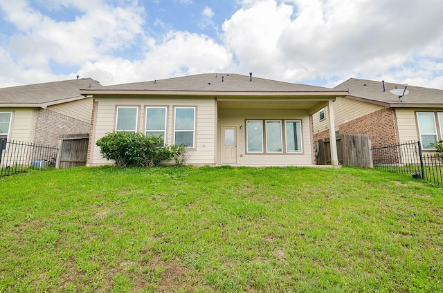 rear view of property featuring a fenced backyard and a yard