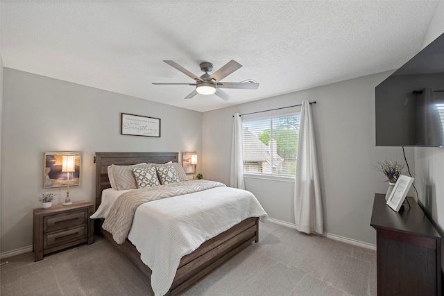 bedroom with light colored carpet, a textured ceiling, baseboards, and ceiling fan