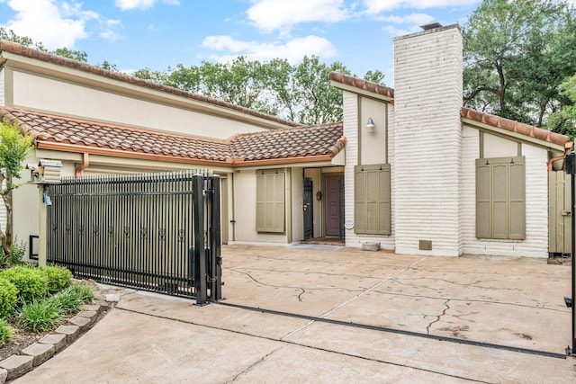 6103 Gallant Forest Dr, Houston, TX 77088 - back of property with stucco siding, a chimney, a gate, a tiled roof, and a fenced front yard