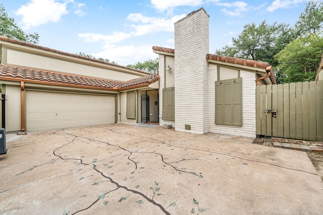 6103 Gallant Forest Dr, Houston, TX 77088 - view of front of property featuring driveway, a chimney, a tile roof, an attached garage, and stucco siding