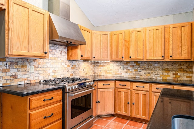 6103 Gallant Forest Dr, Houston, TX 77088 - kitchen featuring wall chimney exhaust hood, stainless steel range with gas cooktop, light tile patterned floors, tasteful backsplash, and vaulted ceiling