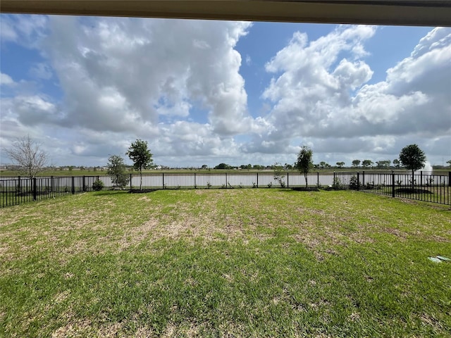 view of yard featuring a water view and a fenced backyard