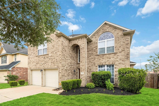 view of front of property featuring a garage, fence, a front yard, brick siding, and driveway