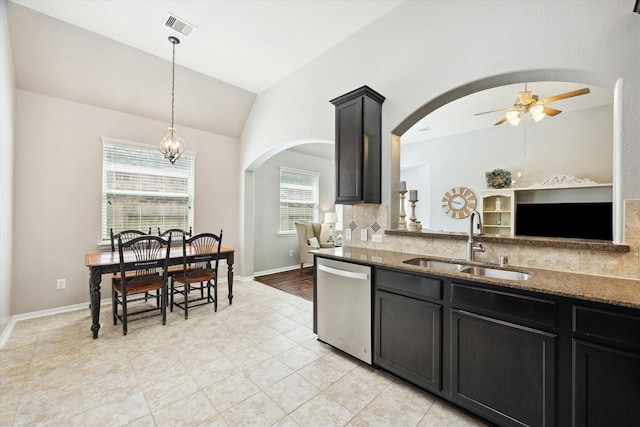 kitchen featuring visible vents, arched walkways, a sink, dark stone countertops, and dishwasher