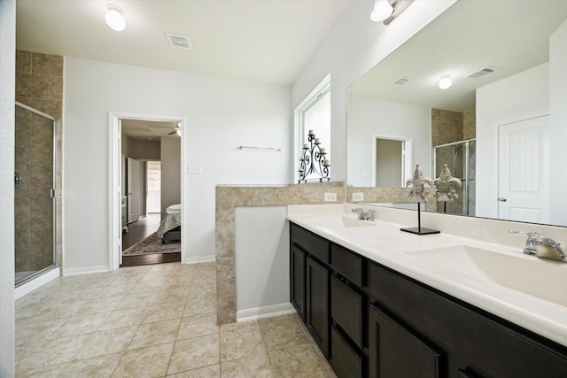 ensuite bathroom with visible vents, a sink, a stall shower, and double vanity