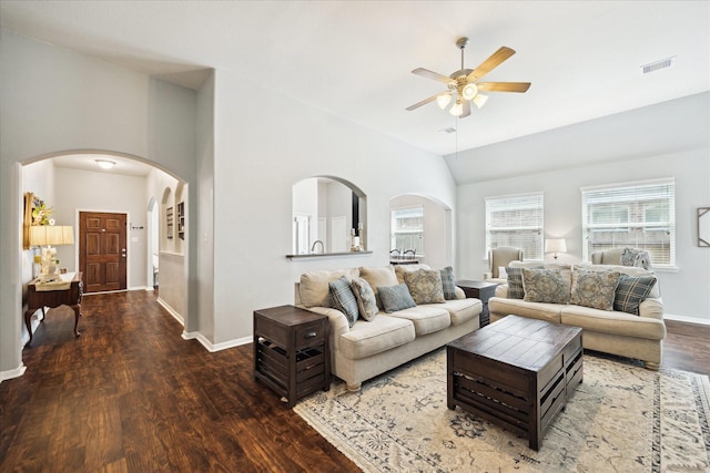 living room with arched walkways, a ceiling fan, wood finished floors, and visible vents