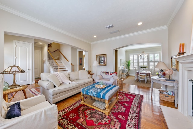 living area featuring light wood-style floors, arched walkways, stairs, and visible vents