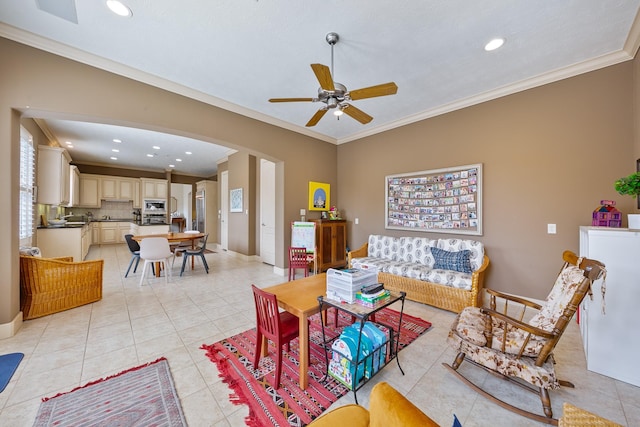 living area featuring light tile patterned floors, arched walkways, ceiling fan, and ornamental molding