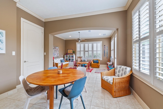 dining space with a ceiling fan, arched walkways, and a wealth of natural light