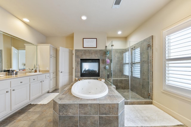 full bath featuring visible vents, double vanity, a whirlpool tub, a shower stall, and a sink