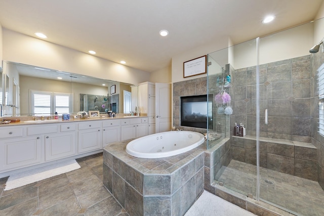 bathroom featuring recessed lighting, a shower stall, a jetted tub, and vanity