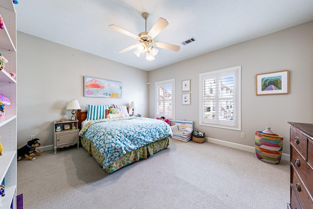 carpeted bedroom with a ceiling fan, baseboards, and visible vents