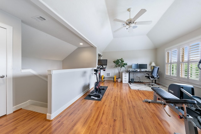 exercise room with a ceiling fan, baseboards, wood finished floors, lofted ceiling, and visible vents