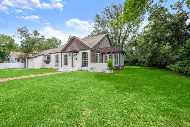 back of property with an attached garage, a lawn, a pergola, and brick siding