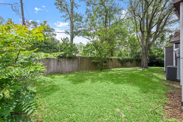 view of yard with a fenced backyard and central AC