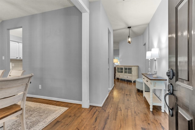 hallway featuring baseboards and wood finished floors
