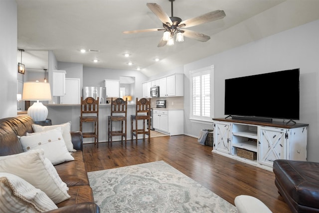 living room with vaulted ceiling, a ceiling fan, and dark wood finished floors