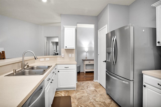 kitchen featuring light countertops, a sink, white cabinets, and stainless steel appliances