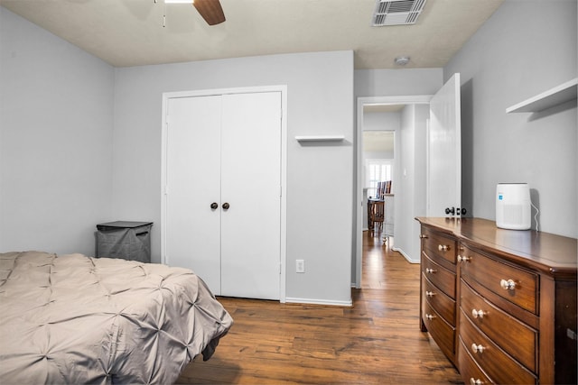 bedroom featuring visible vents, a closet, baseboards, ceiling fan, and dark wood-type flooring