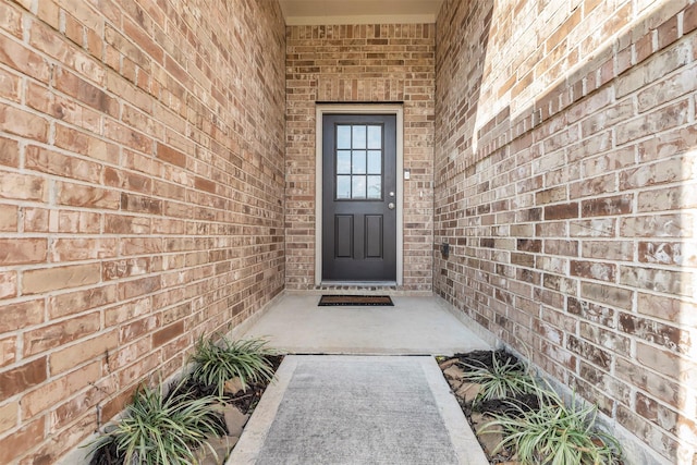 property entrance featuring brick siding