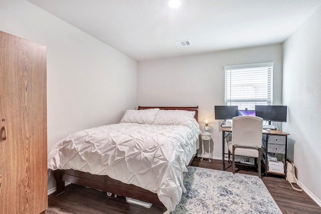 bedroom featuring baseboards, wood finished floors, and visible vents