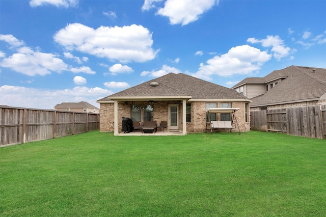 rear view of property featuring a fenced backyard, a yard, a patio area, and brick siding