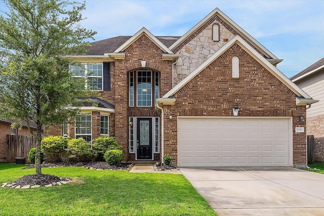 traditional-style house featuring a front yard, a garage, brick siding, fence, and concrete driveway