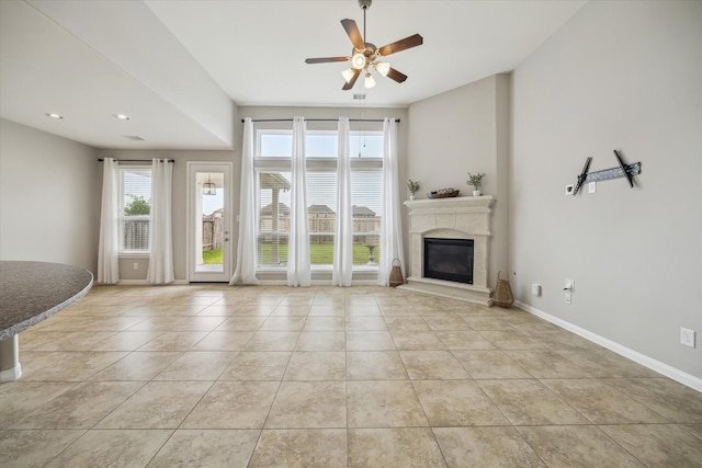 unfurnished living room featuring a glass covered fireplace, baseboards, ceiling fan, recessed lighting, and tile patterned floors