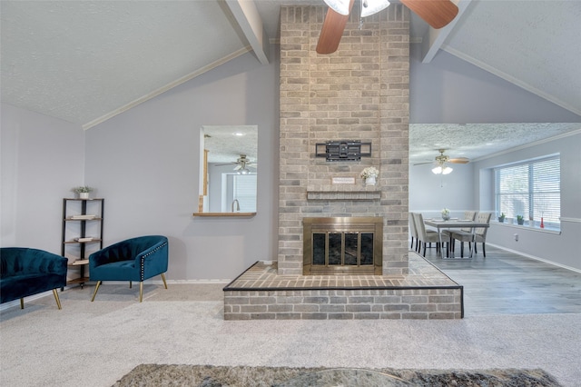carpeted living room with baseboards, a ceiling fan, lofted ceiling with beams, and a fireplace