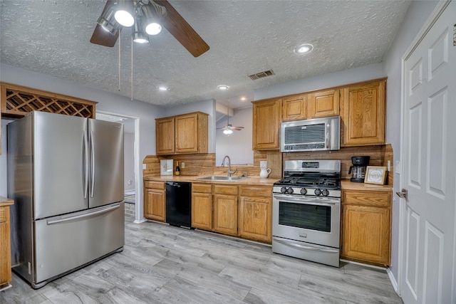 kitchen featuring visible vents, a sink, light countertops, a ceiling fan, and appliances with stainless steel finishes