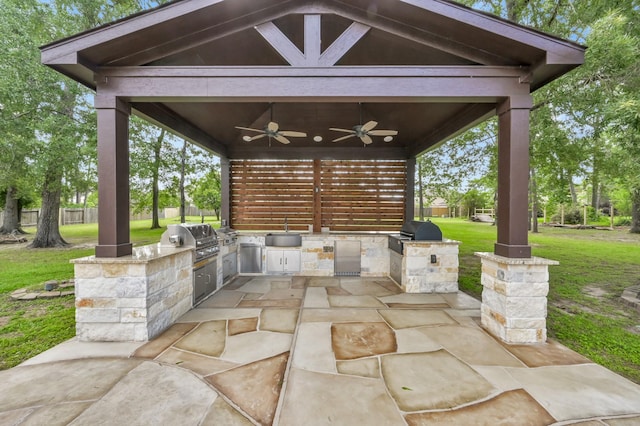 view of patio with ceiling fan, exterior kitchen, a sink, and area for grilling
