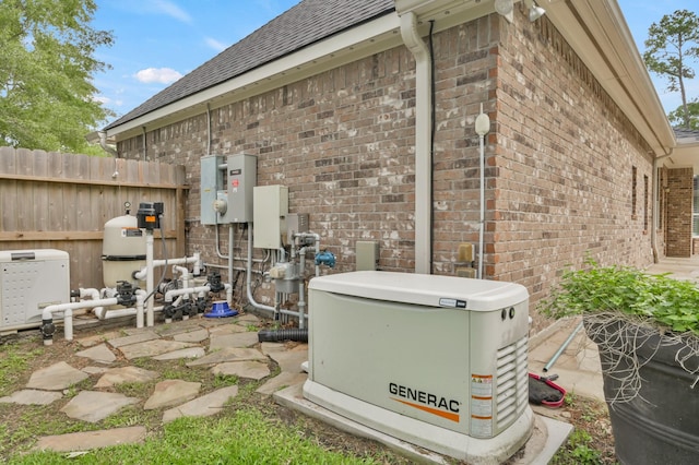 exterior details with brick siding, a power unit, pump, and fence
