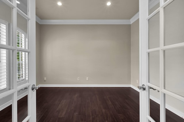 empty room featuring baseboards, ornamental molding, and dark wood-type flooring