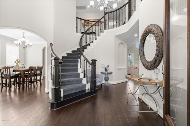 entrance foyer featuring plenty of natural light, stairs, and a chandelier