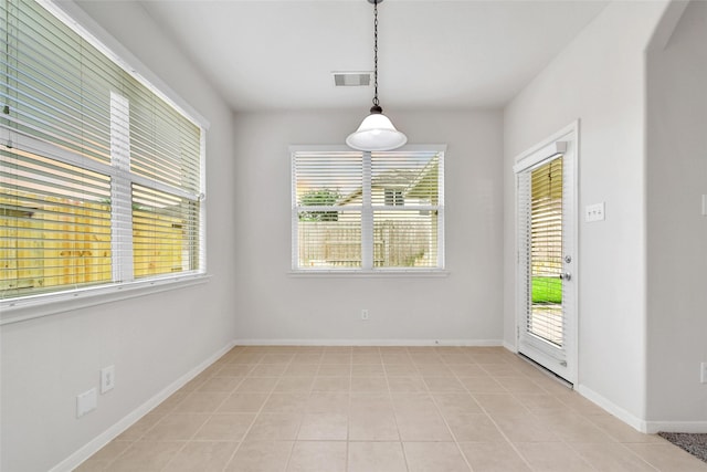 unfurnished dining area with visible vents, light tile patterned floors, and a healthy amount of sunlight