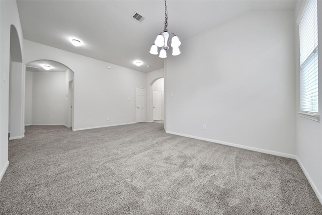 spare room with visible vents, arched walkways, carpet floors, lofted ceiling, and an inviting chandelier
