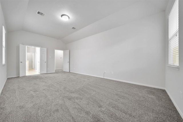 unfurnished bedroom featuring carpet floors, visible vents, and vaulted ceiling