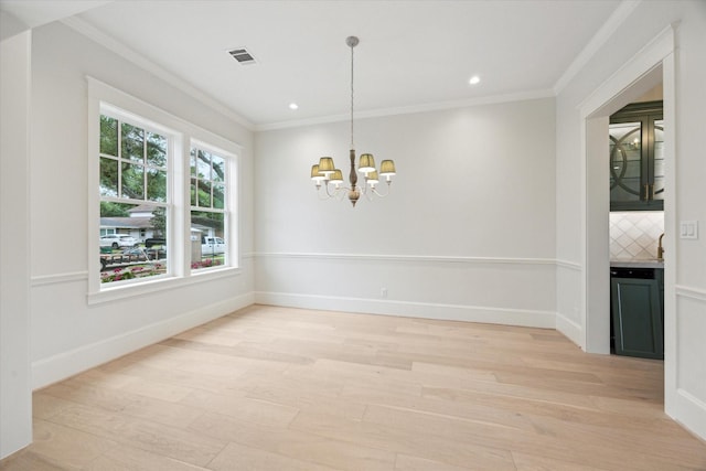 unfurnished dining area with light wood-type flooring, a chandelier, ornamental molding, recessed lighting, and baseboards