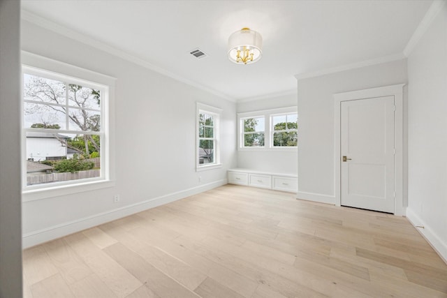 unfurnished room with a chandelier, light wood-style floors, baseboards, and ornamental molding